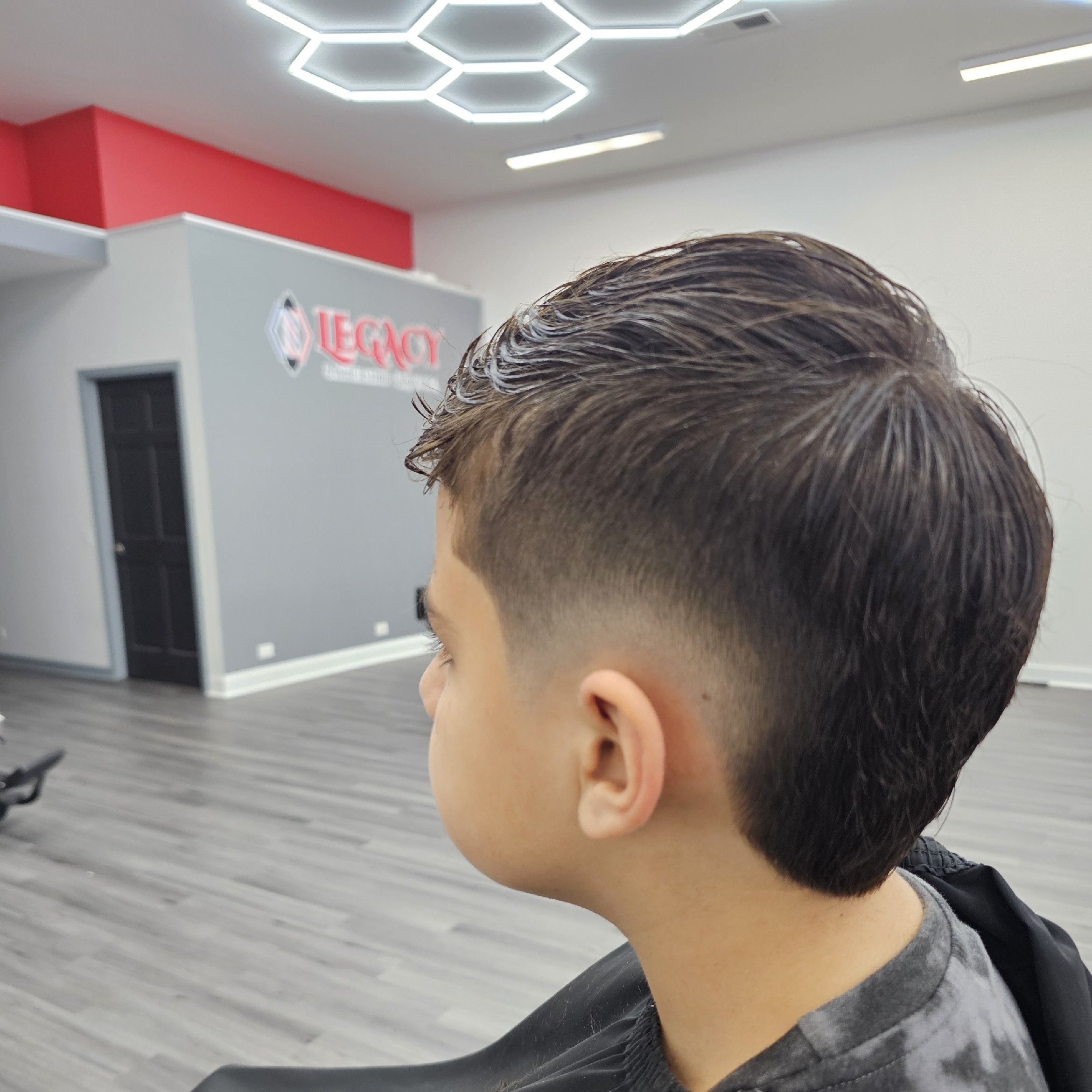 Textured crop with skin fade under the honeycomb lights, Legacy Barbershop & Lounge